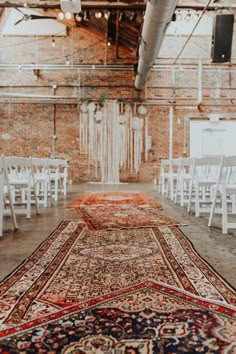 an old rug is on the ground in front of white chairs