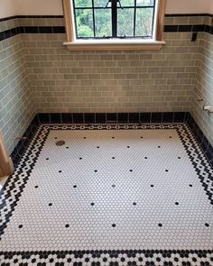 an empty bathroom with black and white tile