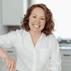 a woman is smiling while preparing food in the kitchen