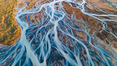 an aerial view of blue water flowing down the side of a mountain range in australia