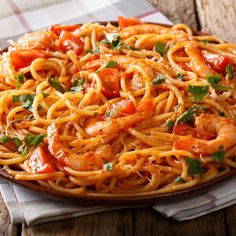 a plate of pasta with shrimp and tomato sauce