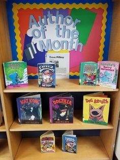 children's books are displayed on shelves in a library with an author of the month sign behind them