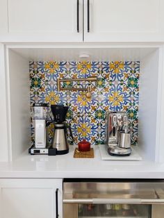 a kitchen counter with coffee maker and other items on it's shelf in front of the oven