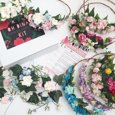 three flower wreaths are laying on the table next to a book and some papers