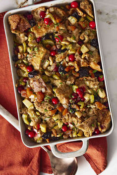 a casserole dish filled with stuffing and cranberries