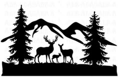 two deer standing in front of trees and mountains