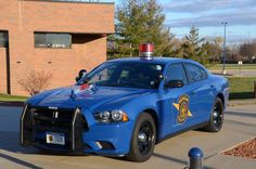 a blue police car parked in front of a building with a red light on top