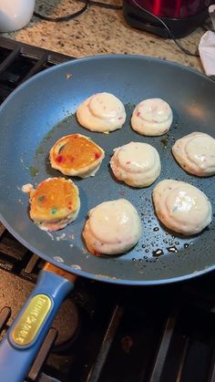 eggs are being cooked in a frying pan on the stove top with other food items