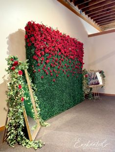 red flowers are growing on the side of a green wall in an office building,