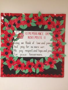 a red and black frame with flowers on it that says remembrance day november 11, today we think of love and peace