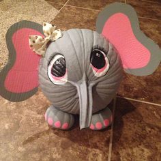 an elephant stuffed animal sitting on top of a tile floor