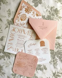 wedding stationery and envelopes laid out on a bed