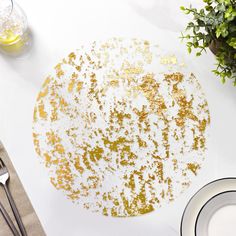 a white table topped with a plate covered in gold flecks and confetti