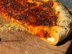 a slice of pepperoni pizza sitting on top of a wooden cutting board