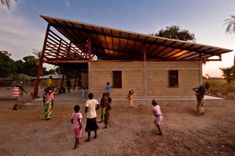 several children are playing in front of a building with a wooden roof and awning