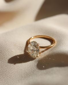 a diamond ring sitting on top of a white cloth