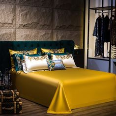 a bed with yellow sheets and pillows in a room