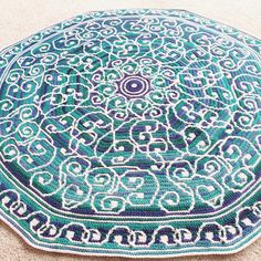 a blue and white rug on the floor with an intricate design in it's center