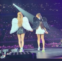 two girls in angel wings on stage at a concert