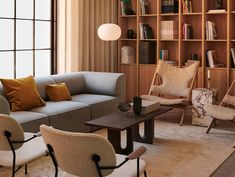 a living room filled with furniture and bookshelves next to a large open window