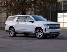 a white chevrolet suburban parked in front of a building