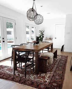 the dining room table is surrounded by chairs and rugs