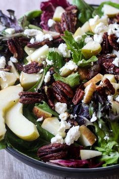 an apple pecan and feta lettuce salad is shown in a bowl