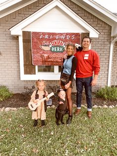 three people standing in front of a brick building with fake dolls on the lawn next to them