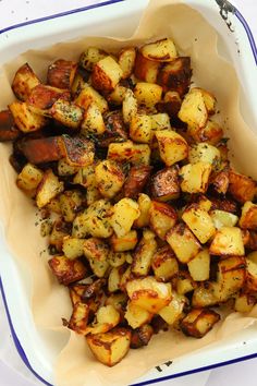 a white bowl filled with cooked potatoes on top of a table