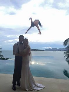 a man and woman standing next to each other in front of a pool