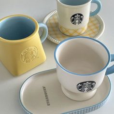 three coffee cups and saucers sitting on top of each other with the same design