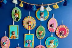 there are many colorful plates hanging on the wall with tassels attached to them