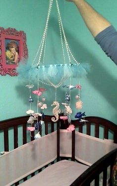 a baby's crib with a chandelier hanging from the ceiling in front of it