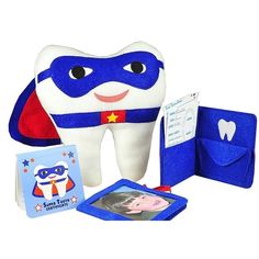 a tooth with a blue cape and other items including a book, photo frame, and card holder