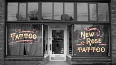 a tattoo shop with two large windows and signs on the front door that say,'new rose tattoo '