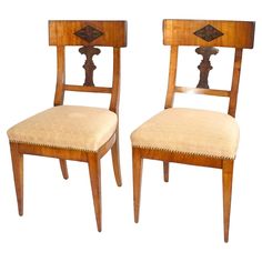 a pair of wooden chairs sitting next to each other