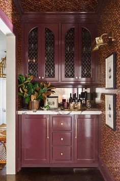 a kitchen with wooden cabinets and leopard print wallpaper on the walls, along with a potted plant