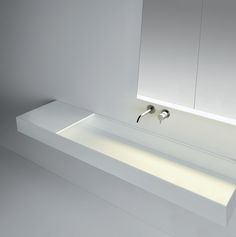 a white bathroom sink with two faucets on it's sides and a mirror above it