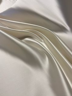 This beautiful white Bridal Satin fabric is perfect for all of your formal garment projects. Imagine the most beautiful wedding dress in this expensive nonstretch Satin.  This fabric is recycled and it is the excess of a previous project. The total amount of fabric is 3 yards available.  $4.00 per yard. You can get this fabric cut per yard.  Please note:  If you would like to purchase all 3 yards of fabric, you can send me an email and I'll send you an invoice to purchase the fabric. That price Elegant Silk Fabric For Evening, Elegant Evening Silk Fabric, Elegant Silk Fabric For Formal Occasion, Elegant Silk Fabric With Satin Finish, Cream Silk Fabric For Wedding, Elegant Satin Fabric For Wedding, Elegant Beige Fabric For Wedding, Elegant Beige Wedding Fabric, Elegant Wedding Satin Fabric