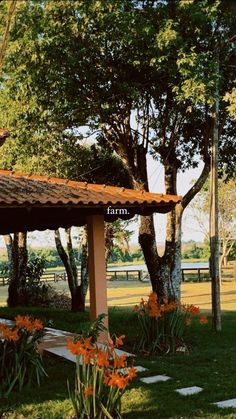 an open area with flowers and trees in the background