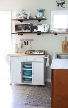 a kitchen with white cabinets and open shelves