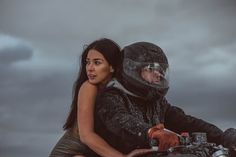 a man riding on the back of a motorcycle next to a woman