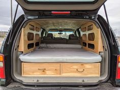 the back end of a van with its cargo compartment open and two drawers on each side