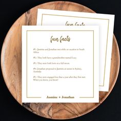 two cards on a wooden plate with the words fun faks written in gold ink