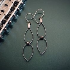 two pairs of earrings sitting on top of a table next to an old typewriter