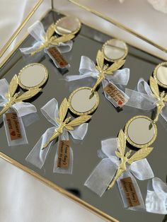 a glass tray with some gold and white decorations on it's sides, along with tags that say i do not know what they are