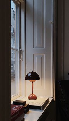 a lamp sitting on top of a table next to a window