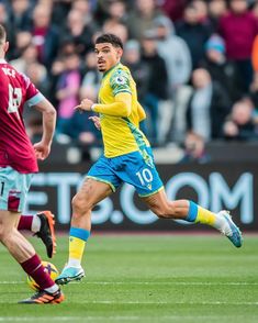 two soccer players are running after the ball