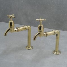 two brass faucets with matching handles on each side