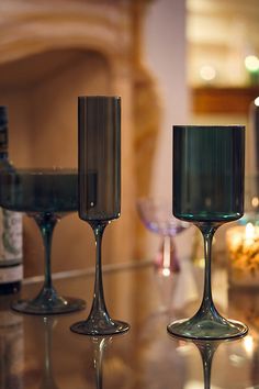 three wine glasses sitting on top of a table